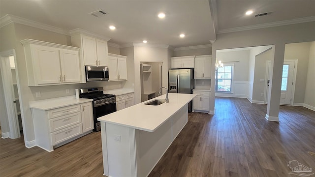 kitchen with a kitchen island with sink, sink, white cabinets, and appliances with stainless steel finishes