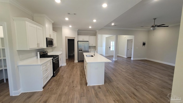 kitchen with a kitchen island with sink, a sink, appliances with stainless steel finishes, white cabinets, and dark wood-style flooring