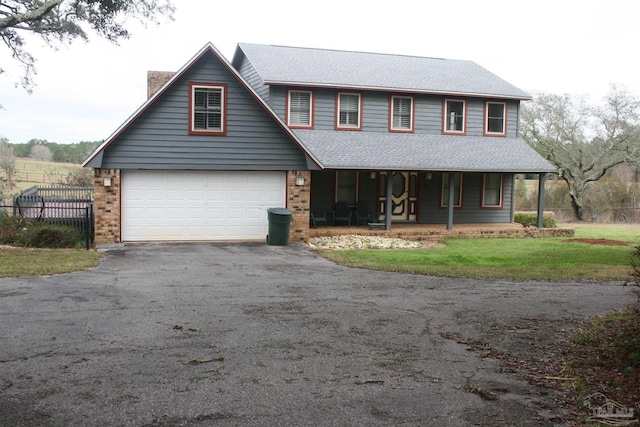 view of front of property with a garage, covered porch, and a front lawn