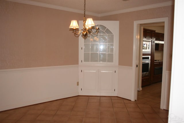 unfurnished dining area featuring crown molding, tile patterned floors, and a chandelier