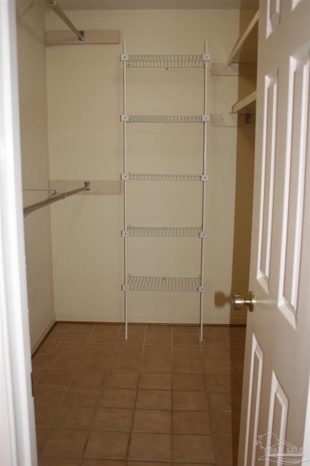 spacious closet with dark tile patterned flooring