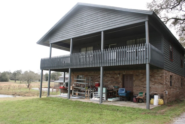 back of house featuring a lawn, a balcony, and a patio area