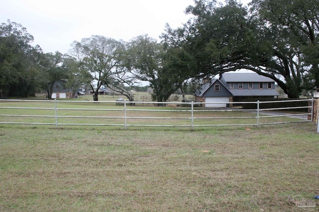 view of yard featuring a rural view and a garage