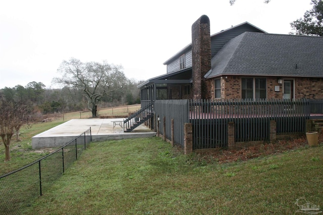 exterior space with a wooden deck, a yard, a sunroom, and a patio