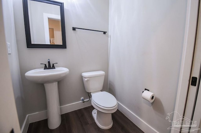 bathroom with wood-type flooring, toilet, and sink