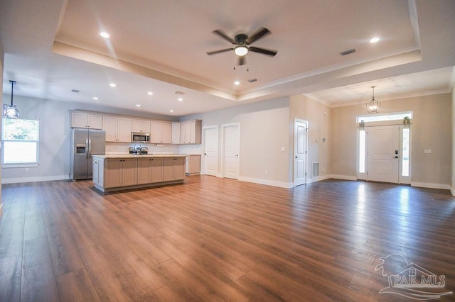 kitchen featuring a center island with sink, dark hardwood / wood-style floors, decorative light fixtures, and appliances with stainless steel finishes