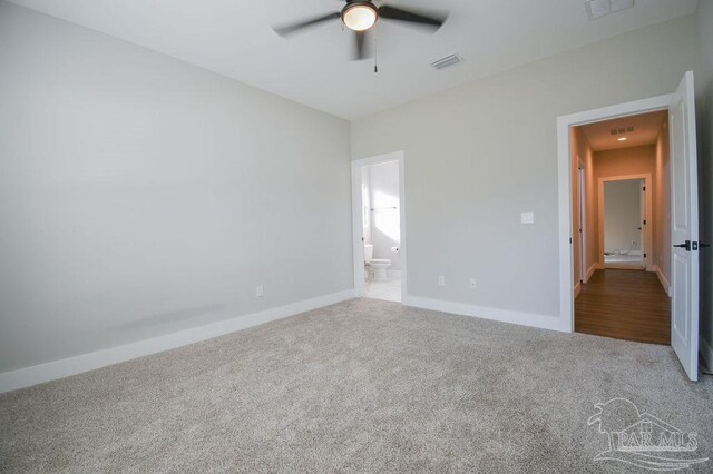 unfurnished bedroom featuring carpet, ensuite bath, and ceiling fan