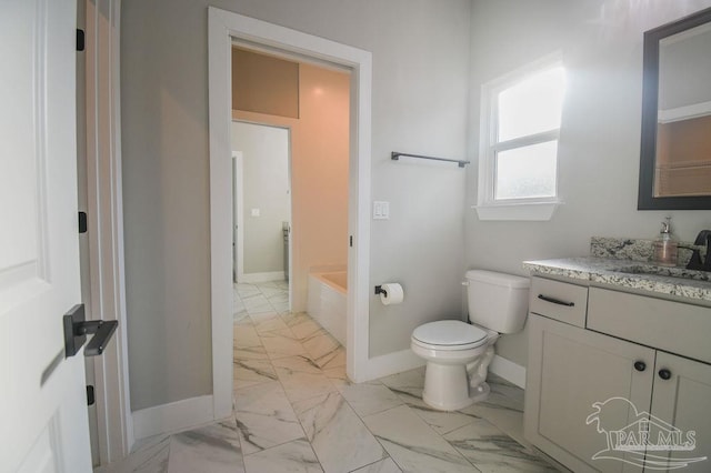 bathroom with vanity, a bath, and toilet