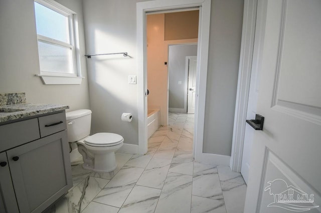 bathroom with vanity, toilet, and a tub to relax in