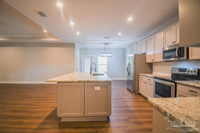 kitchen with light stone counters, sink, stainless steel appliances, and dark wood-type flooring