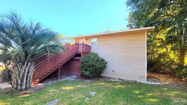 view of side of property featuring a wooden deck and a yard