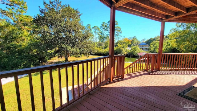 wooden terrace featuring a lawn