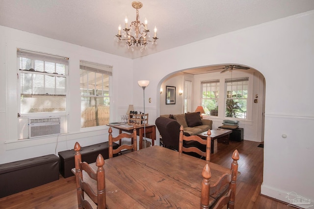 dining space with ceiling fan with notable chandelier, dark hardwood / wood-style flooring, and cooling unit