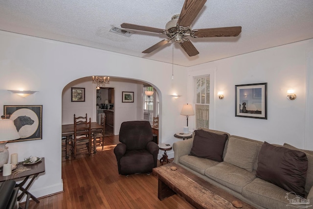 living room featuring a textured ceiling, ceiling fan, and dark hardwood / wood-style floors