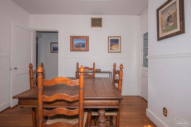 dining space with hardwood / wood-style flooring