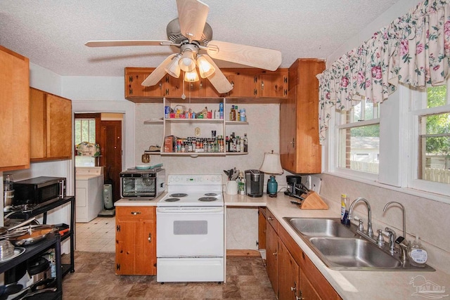 kitchen featuring ceiling fan, electric range, washer / dryer, tile patterned floors, and a textured ceiling