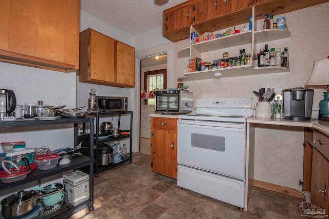 kitchen featuring dark tile patterned flooring, a textured ceiling, and white range with electric stovetop