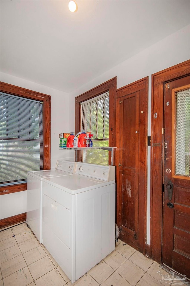 laundry area with light tile patterned floors and washing machine and clothes dryer