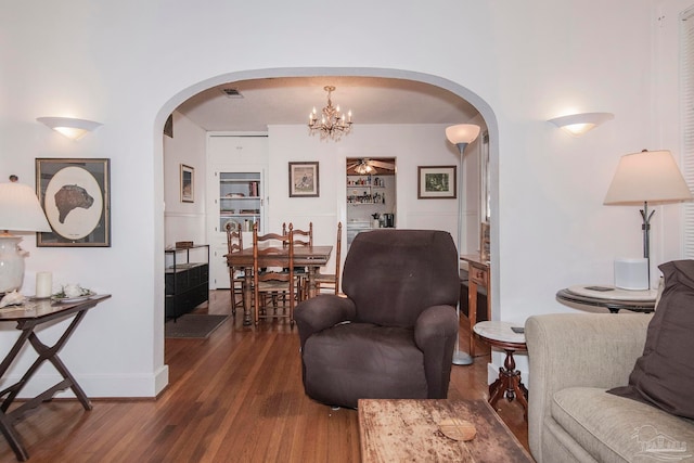 living room with dark wood-type flooring and a chandelier