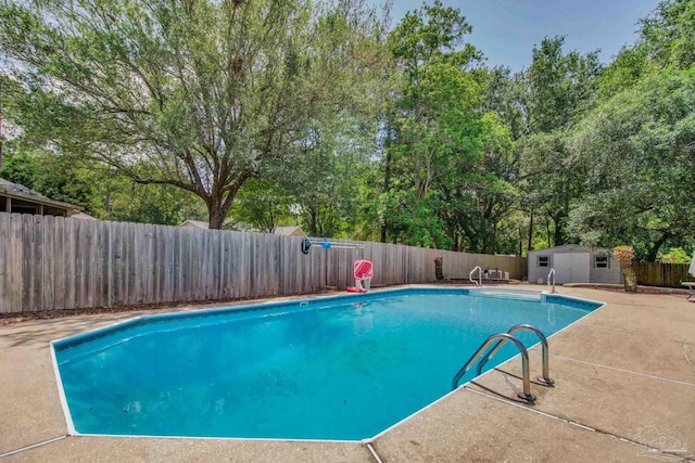 view of pool with a patio area, a fenced backyard, an outdoor structure, a fenced in pool, and a storage unit