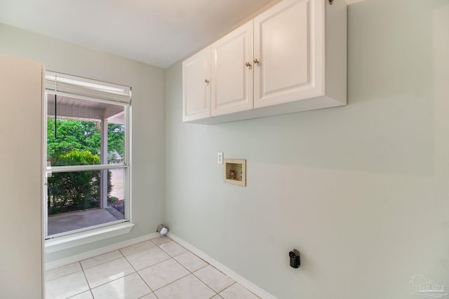 laundry area with cabinet space, hookup for a washing machine, baseboards, and light tile patterned floors
