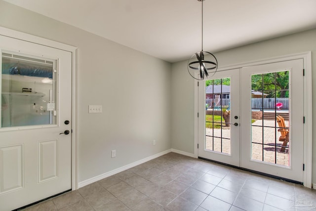 entryway featuring baseboards, light tile patterned flooring, french doors, and a chandelier