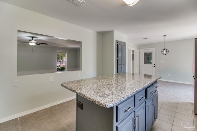 kitchen with ceiling fan, baseboards, and light tile patterned floors
