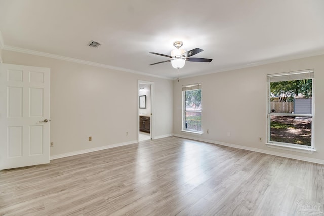 spare room featuring a ceiling fan, crown molding, visible vents, and light wood-style flooring
