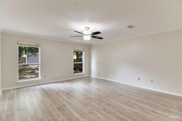 spare room featuring light wood-style flooring, a healthy amount of sunlight, and visible vents