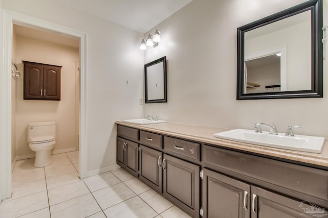 bathroom with tile patterned floors, baseboards, a sink, and toilet
