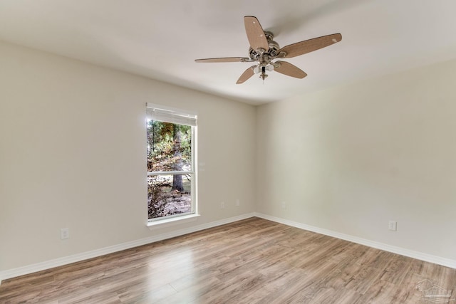 spare room featuring light wood finished floors, baseboards, and ceiling fan