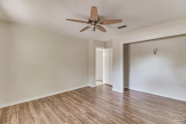 interior space with wood finished floors, visible vents, baseboards, and ceiling fan