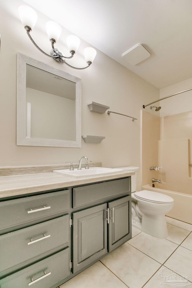 bathroom featuring tile patterned flooring, toilet, vanity, and washtub / shower combination