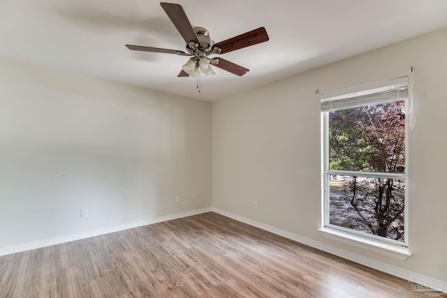 empty room with baseboards, a ceiling fan, and wood finished floors