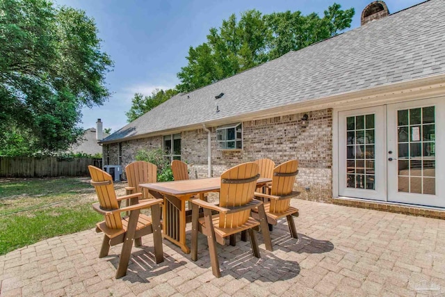 view of patio featuring fence, french doors, outdoor dining area, and central air condition unit