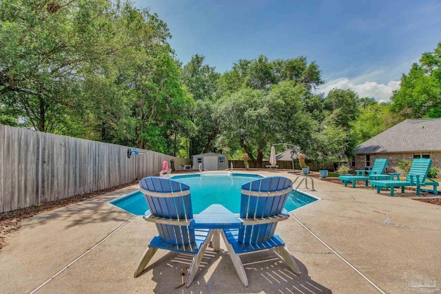 view of pool with an outdoor structure, a patio, a shed, and a fenced in pool