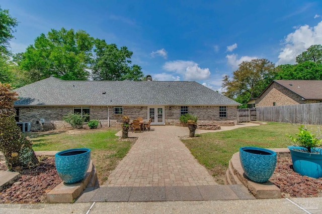 rear view of property with fence, central AC, a patio area, french doors, and a lawn