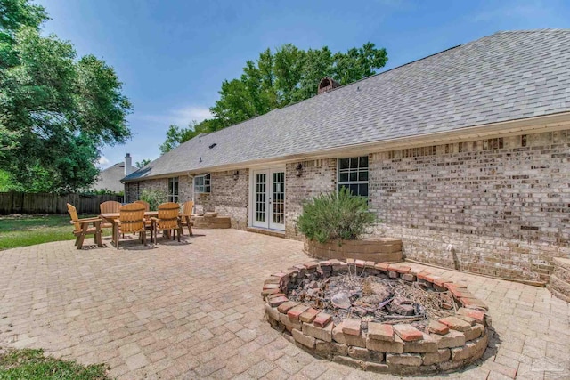 view of patio featuring fence, outdoor dining space, an outdoor fire pit, and french doors