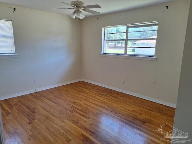 empty room with hardwood / wood-style floors and ceiling fan