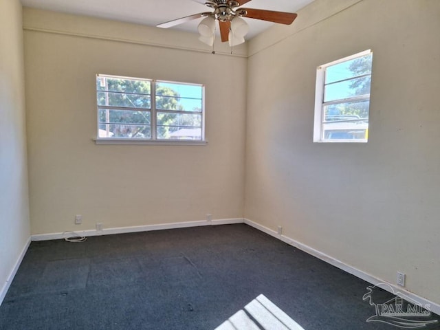 empty room with dark carpet and ceiling fan