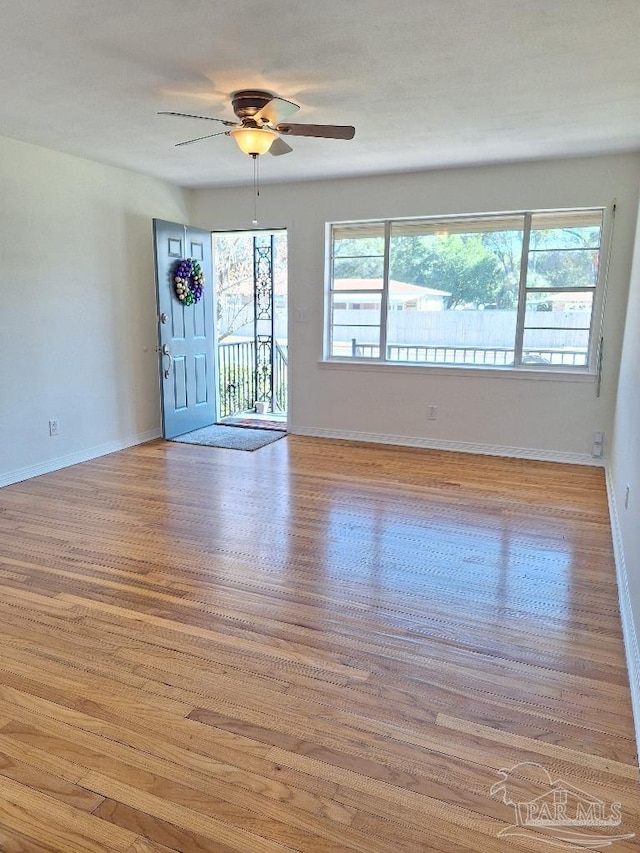 unfurnished living room with plenty of natural light, light hardwood / wood-style floors, and ceiling fan