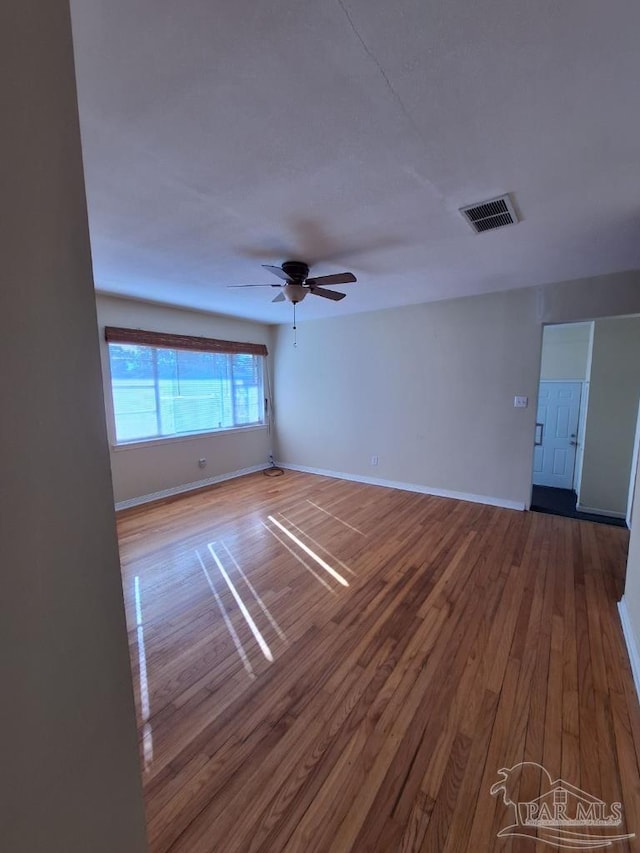 empty room featuring hardwood / wood-style flooring and ceiling fan