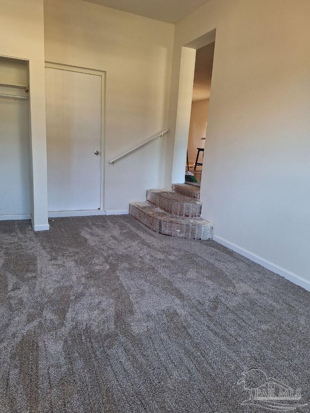 unfurnished living room with dark carpet