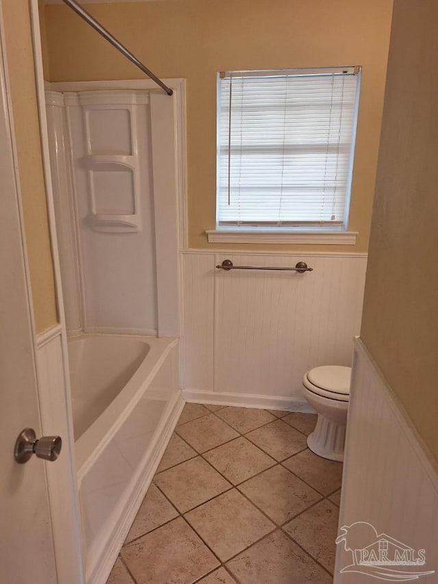 bathroom with tile patterned flooring, bathtub / shower combination, and toilet