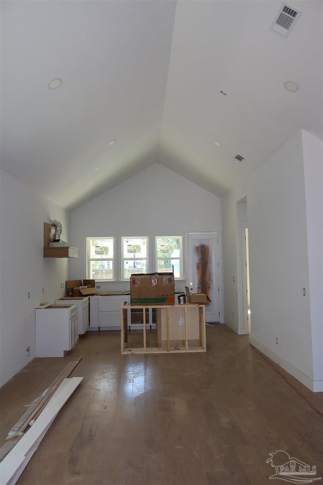 kitchen featuring light wood-type flooring, visible vents, white cabinets, and vaulted ceiling