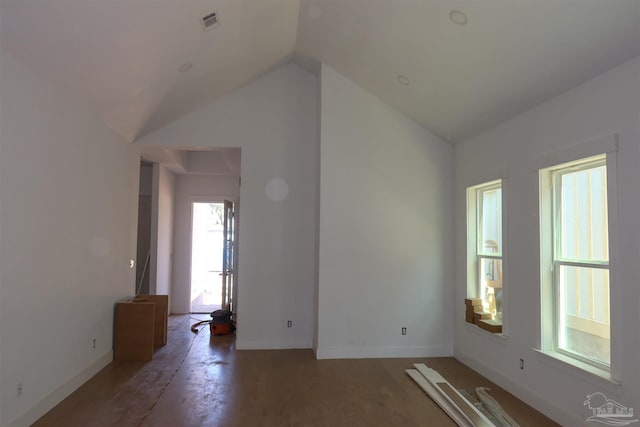 unfurnished room featuring visible vents, baseboards, and lofted ceiling