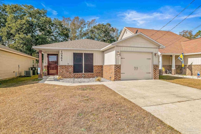 craftsman-style house featuring a garage, cooling unit, and a front lawn