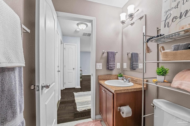 bathroom featuring vanity, wood-type flooring, and toilet