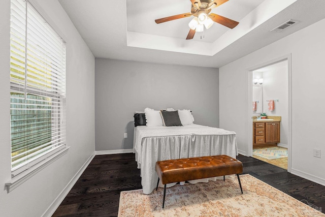 bedroom featuring sink, ceiling fan, dark hardwood / wood-style floors, ensuite bathroom, and a tray ceiling