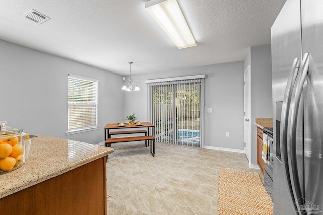 dining area featuring an inviting chandelier and a textured ceiling